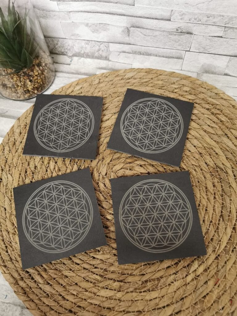 Dessous de verre en ardoise naturelle gravés au laser avec le motif Fleur de Vie, idéal pour décoration intérieure et protection de table.